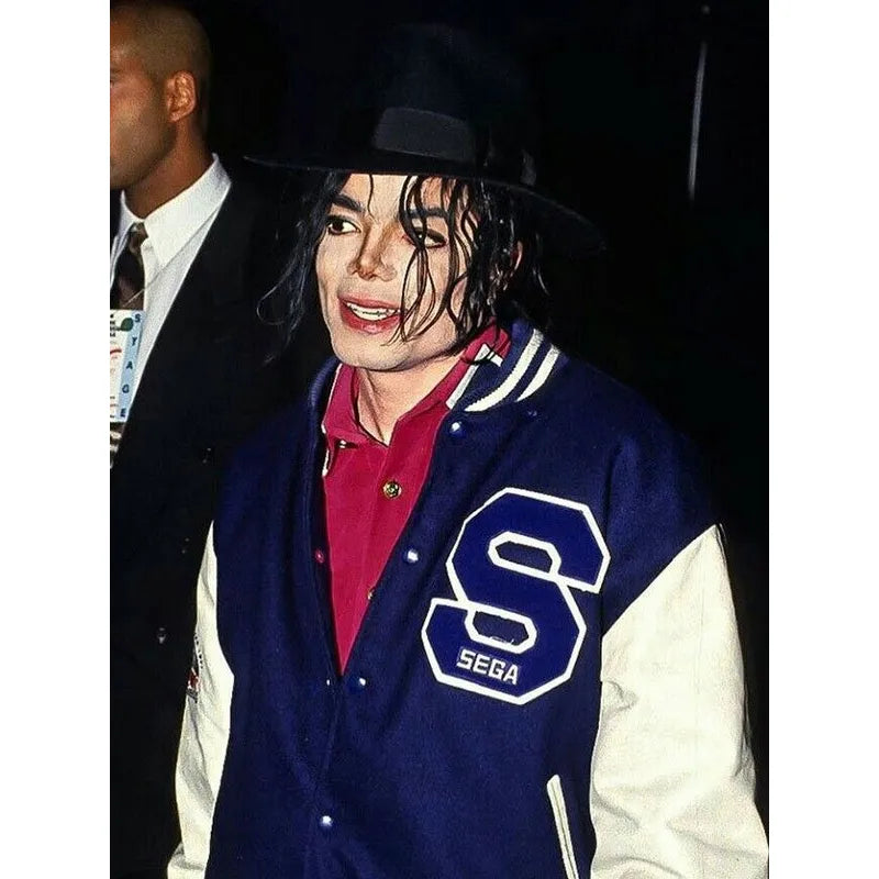 Person wearing a blue letterman jacket with a large 'S' and 'Sega' logo, standing next to another person.