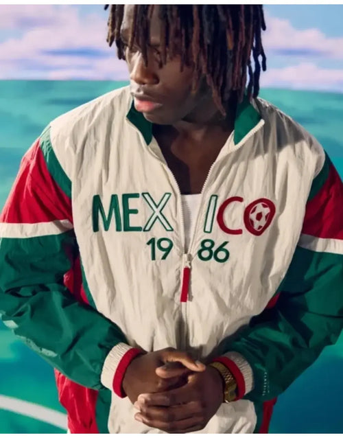 Person wearing a colorful jacket with 'Mexico 1986' text against a scenic background