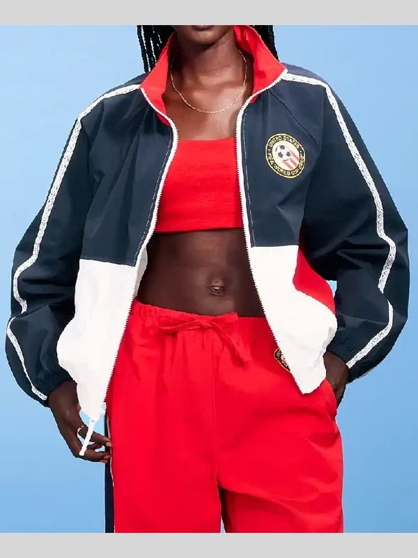 Person wearing a navy, red, and white tracksuit with a blue background