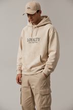 Male model wearing Loyalty sand Premium Logo Hoodie